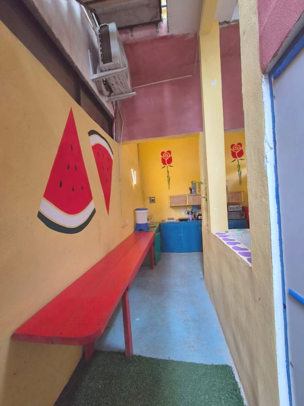 The red bench and watermelon mural outside Two bedroom Delight