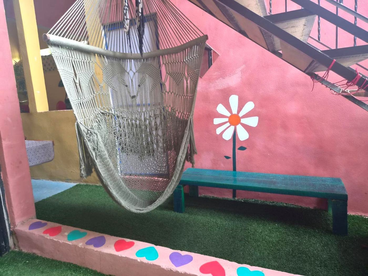A hammock on the terrace at Two bedroom Delight, a painted daisy and hearts along the step