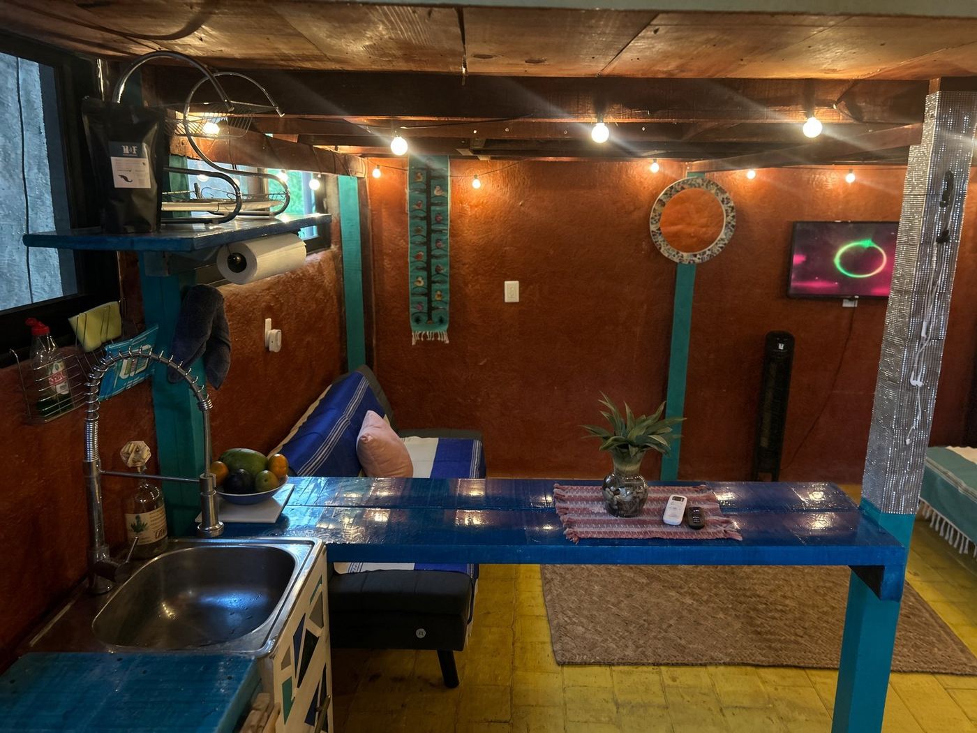 The blue bar at El Loft, fruit on the counter and string lights on the red wall