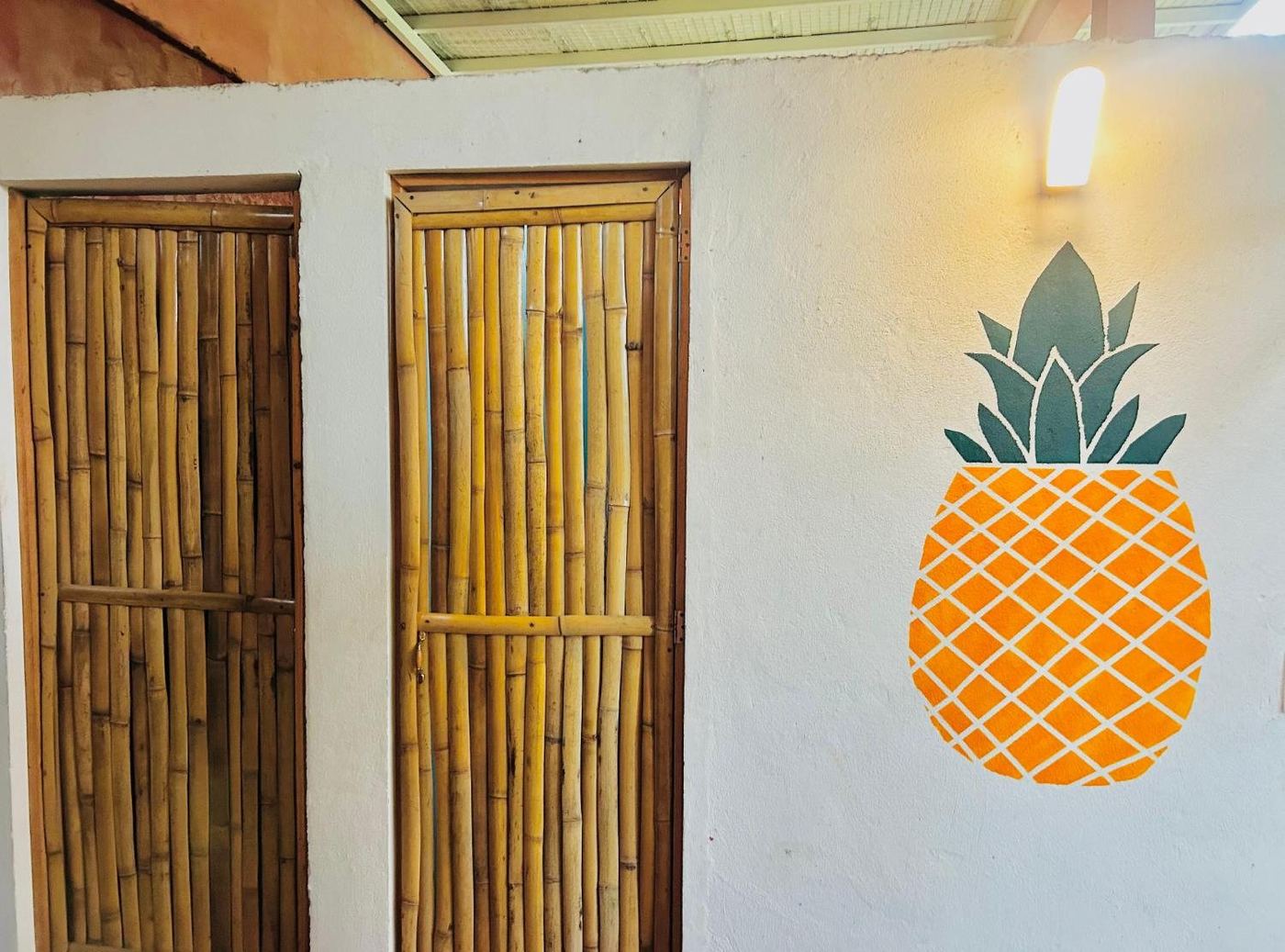 Bamboo doors and a painted pineapple at the entrance to El Loft